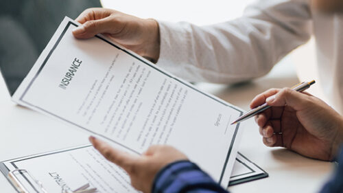 Business professionals holding insurance paperwork.