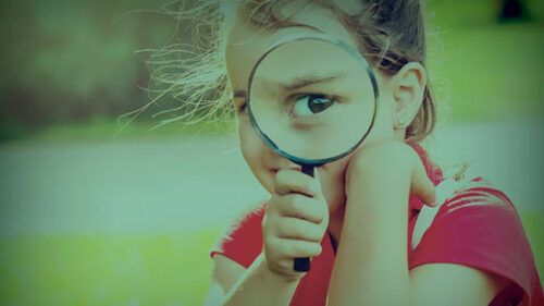 A child looking through a magnifying glass