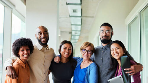 A group of diverse employees smiling for a picture.