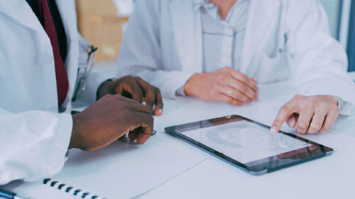 Two healthcare professionals talking over a table.