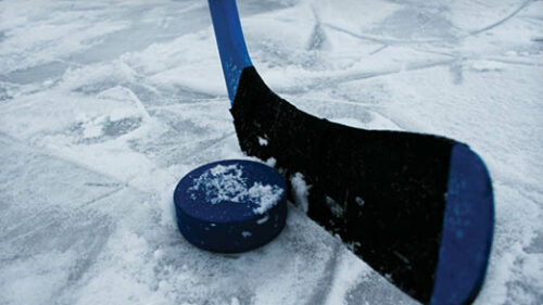 A hockey stick and a puck on ice