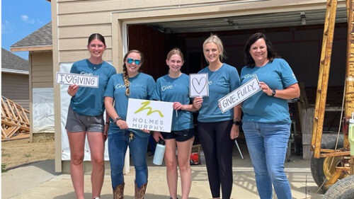 A group of 5 Holmes Murphy employees from the Sioux Falls office wearing Give.Fully. shirts at a volunteer event in 2023.