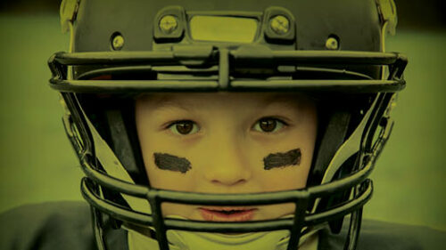 A child wearing a football helmet