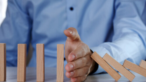 Man with blocks stopping them from falling