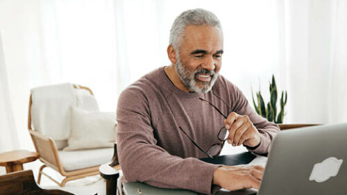 An older employee working from home on his laptop