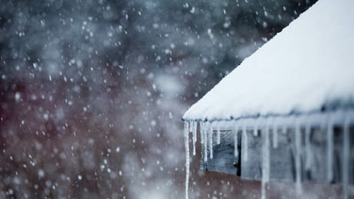 Icicles hanging off a snowy roof.