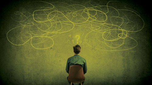 A man staring at a chalk board wondering