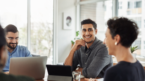 Happy employees sitting around a conference table